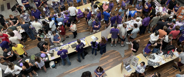 Groups of students milling around tables in the K-State Student Union Courtyard.