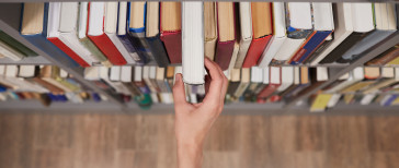 student-taking-book-in-library