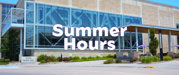 Exterior view of the K-State Student Union on a sunny day, featuring a large glass facade with “K-State” displayed across the windows