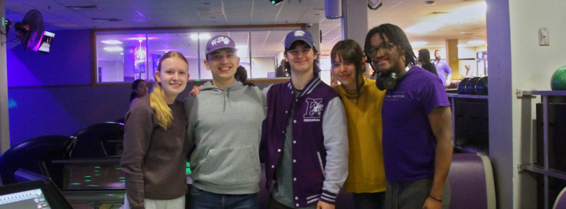 Five people pose in front of a bowling lane at the Wabash Cannon Bowl, located in the lower level of the K-State Student Union. 