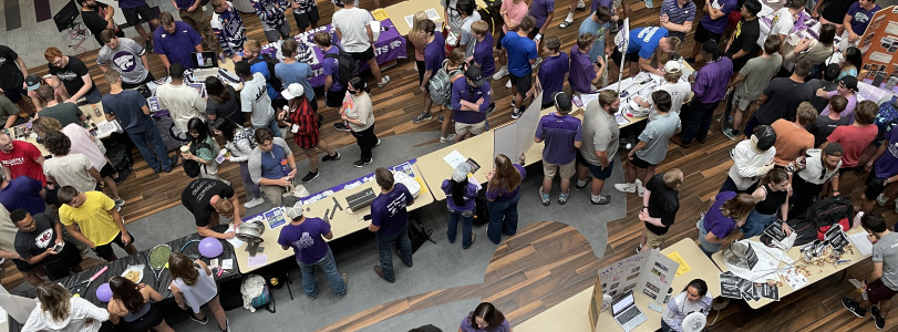 Groups of students milling around tables in the K-State Student Union Courtyard.