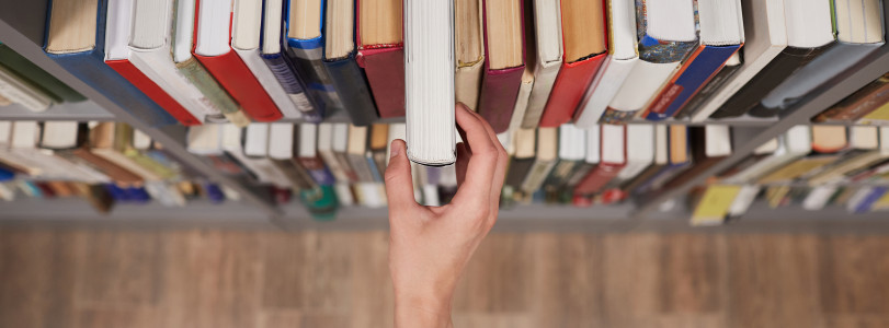 student-taking-book-in-library