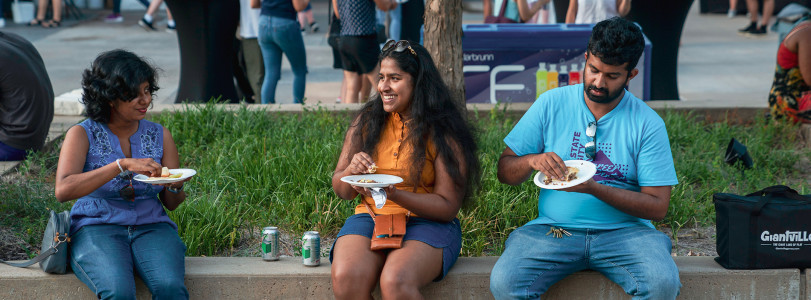 Three people enjoying food truck food outside