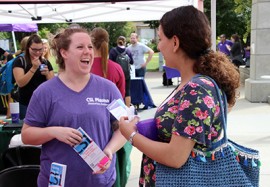 two women laughing at outdoor advertising table